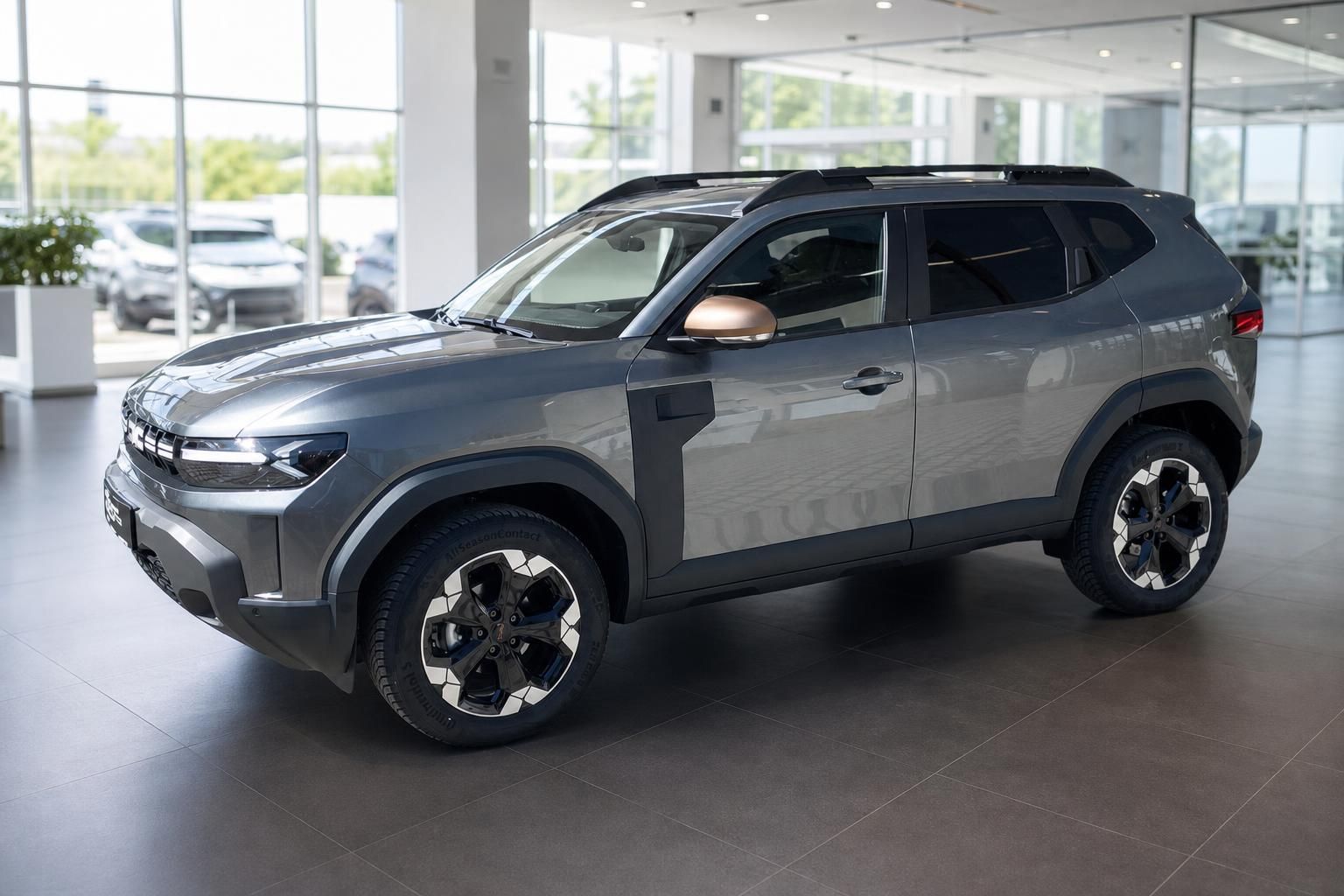 Grauer Dacia Duster SUV - Dreiviertelansicht von vorne links im modernen Autohaus Showroom