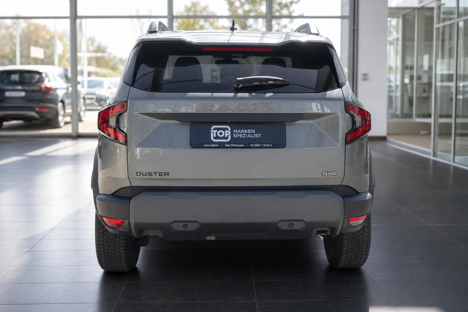 Dacia Duster 4x4 Heckansicht in grau mit Kennzeichen im Autohaus-Showroom