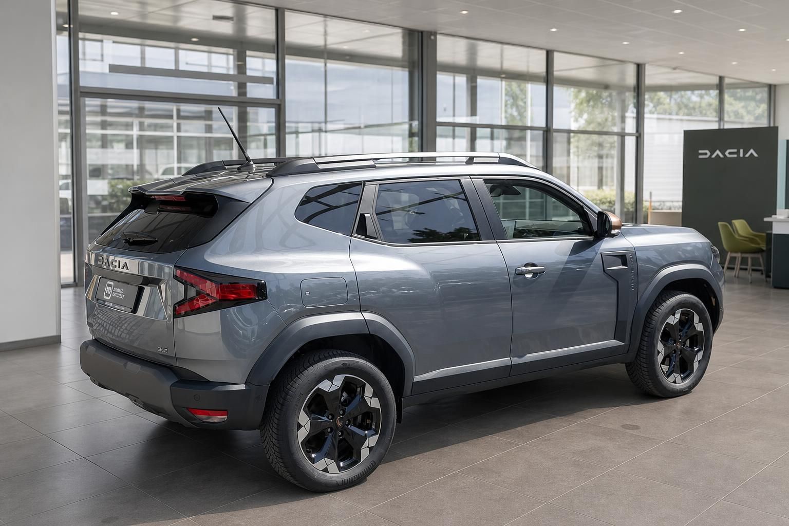 Dacia Duster SUV in grau, Schrägansicht hinten links im Autohaus mit Dacia-Logo im Hintergrund