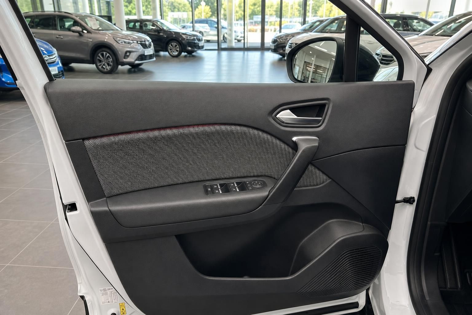 Fahrerseite Türverkleidung mit Fensterheberschaltern und Blick ins Autohaus im Hintergrund