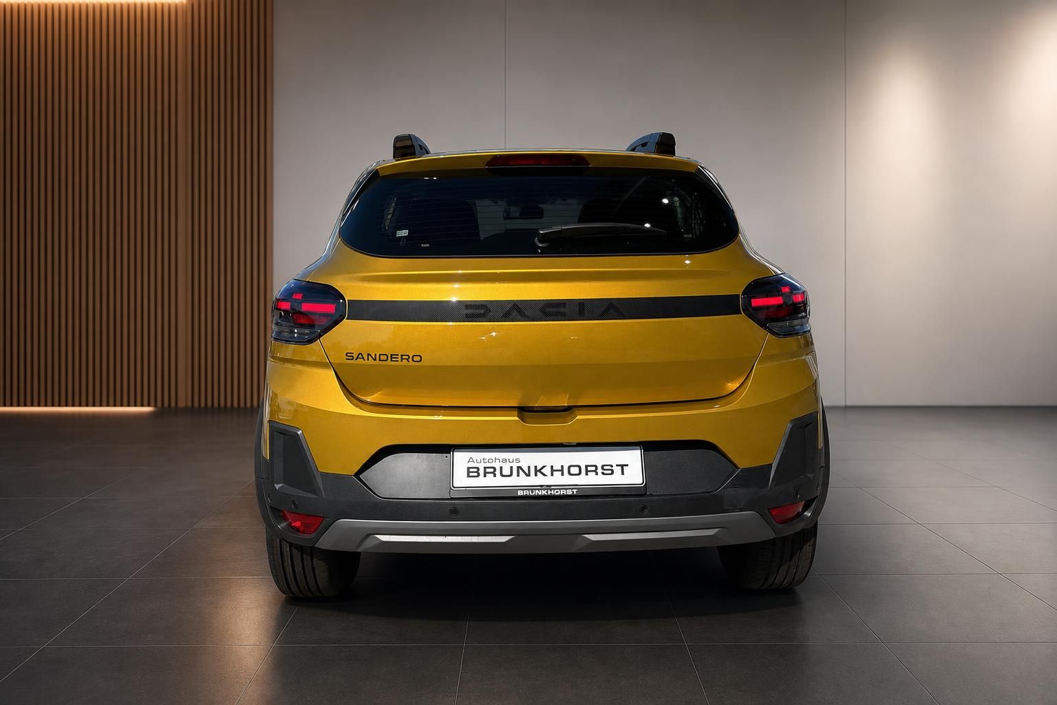 Gelber Dacia Sandero SUV Heckansicht im Autohaus Brünkhorst Showroom