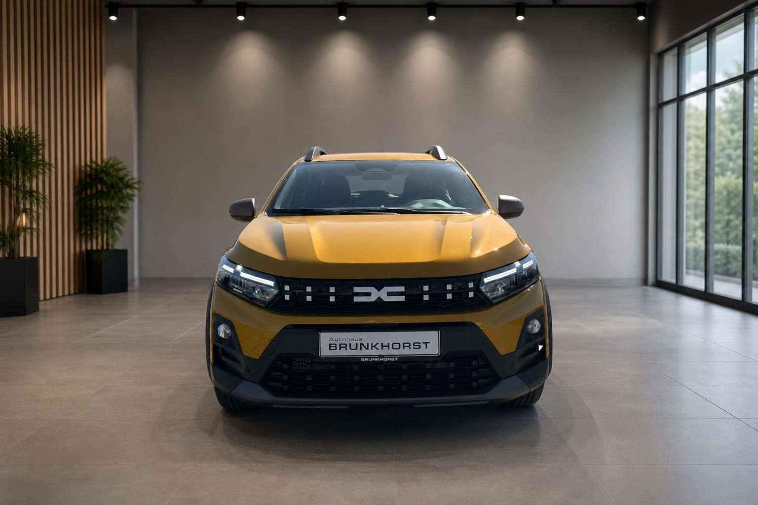 Gelber Dacia Sandero SUV Frontansicht im Autohaus Brünkhorst Showroom