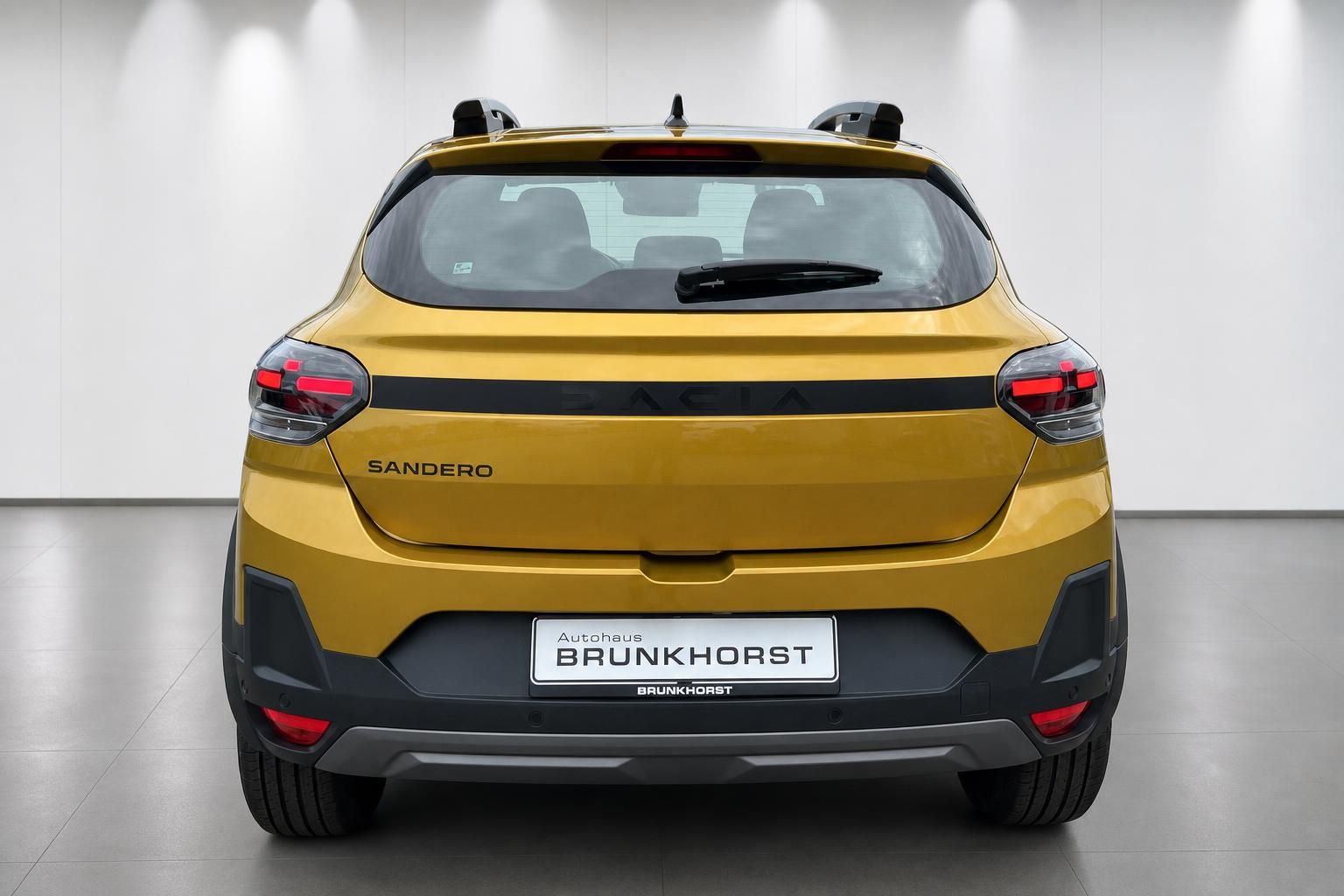 Dacia Sandero gelb, Heckansicht im Autohaus Brunkhorst