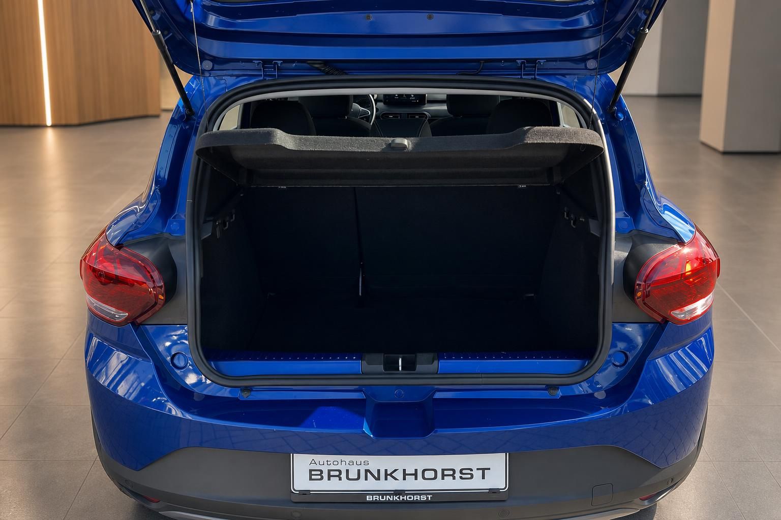 Blauer Kompaktwagen mit geoeffnetem Kofferraum, Ansicht von hinten
