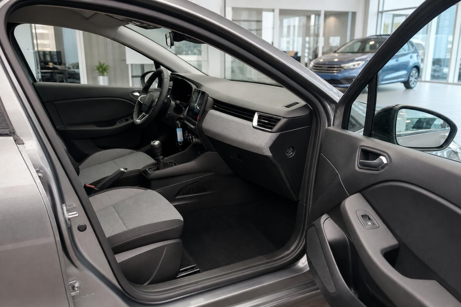 Renault Fahrgastraum mit offener Fahrertür, Sitzen und Armaturenbrett im Autohaus-Showroom