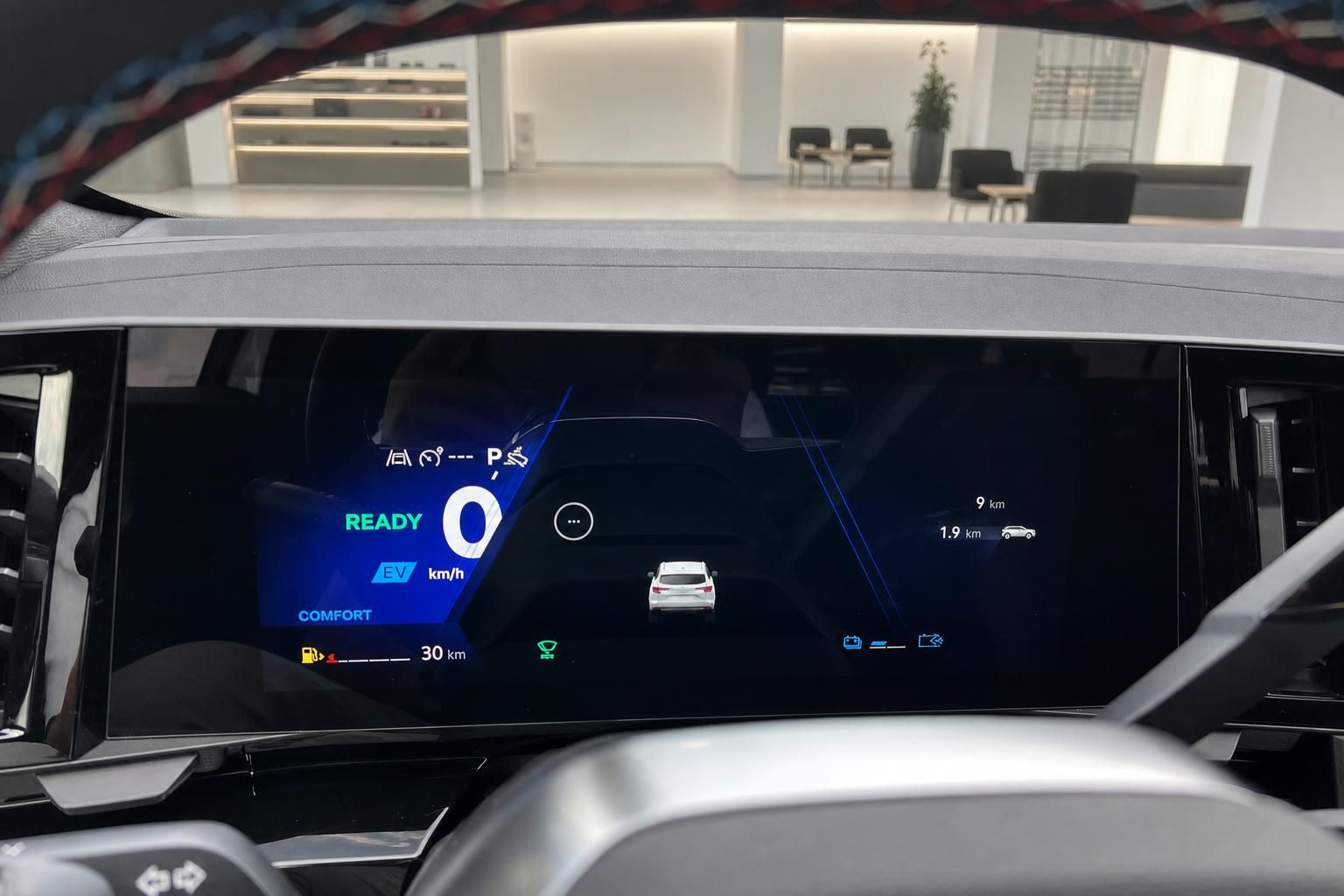 Digitales Kombiinstrument eines weissen Fahrzeugs im Autohaus, EV-Modus Anzeige