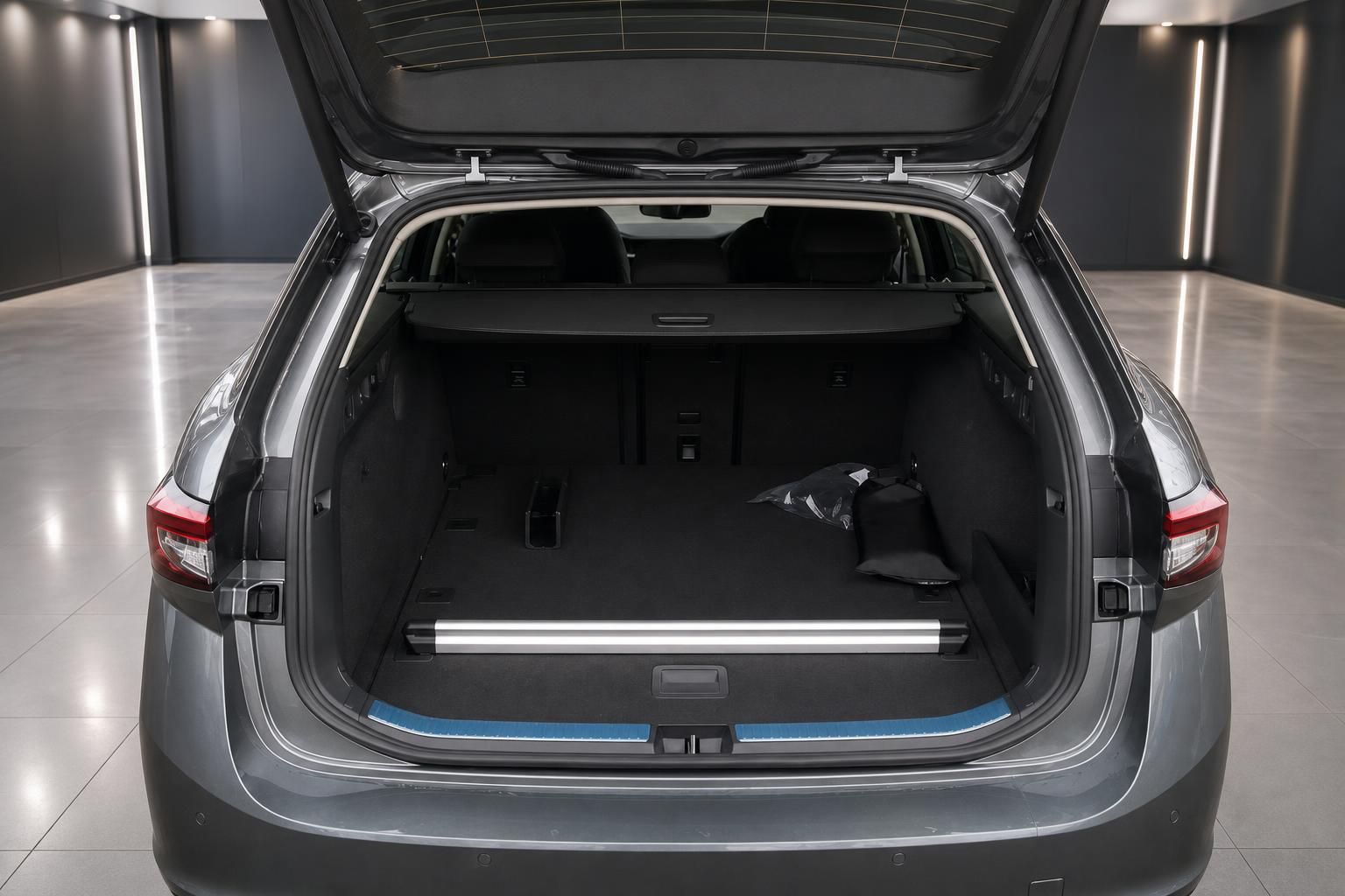 Geöffneter Kofferraum eines grauen Fahrzeugs mit großem Ladevolumen im Showroom