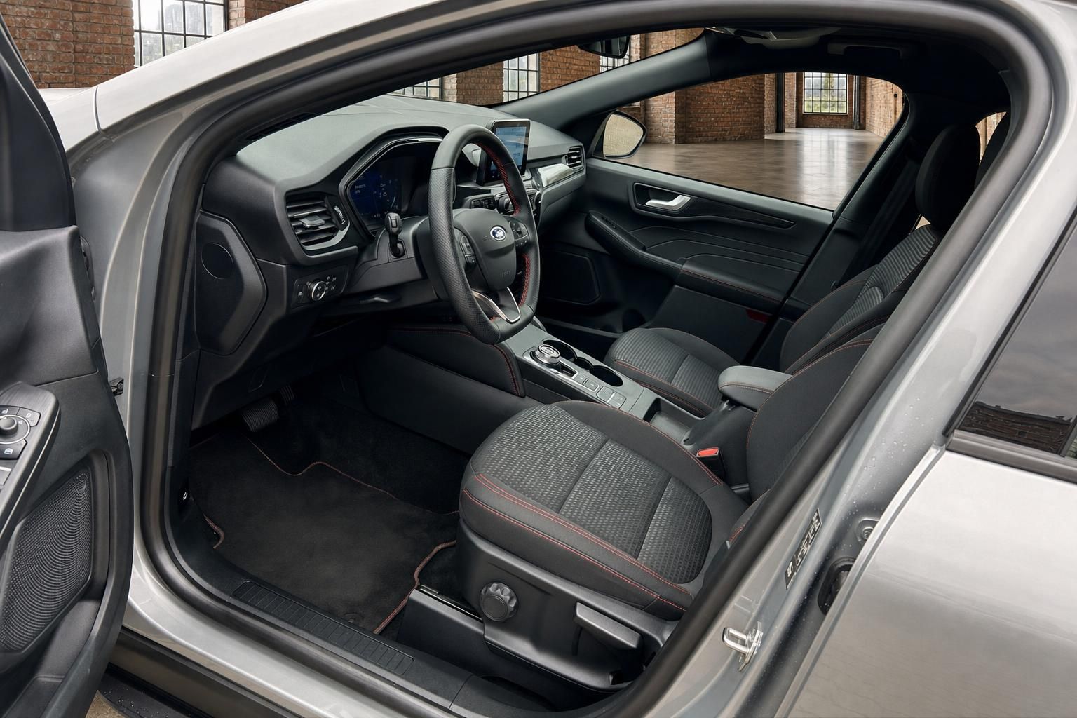 Ford Kuga Innenraum mit Sportsitzen, Lenkrad und Cockpit bei offener Tuer