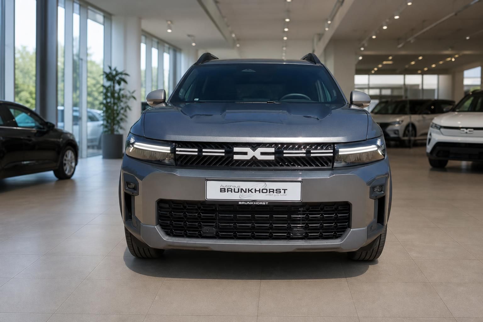 Dacia Bigster Frontansicht in grau mit charakteristischem Kühlergrill im Autohaus