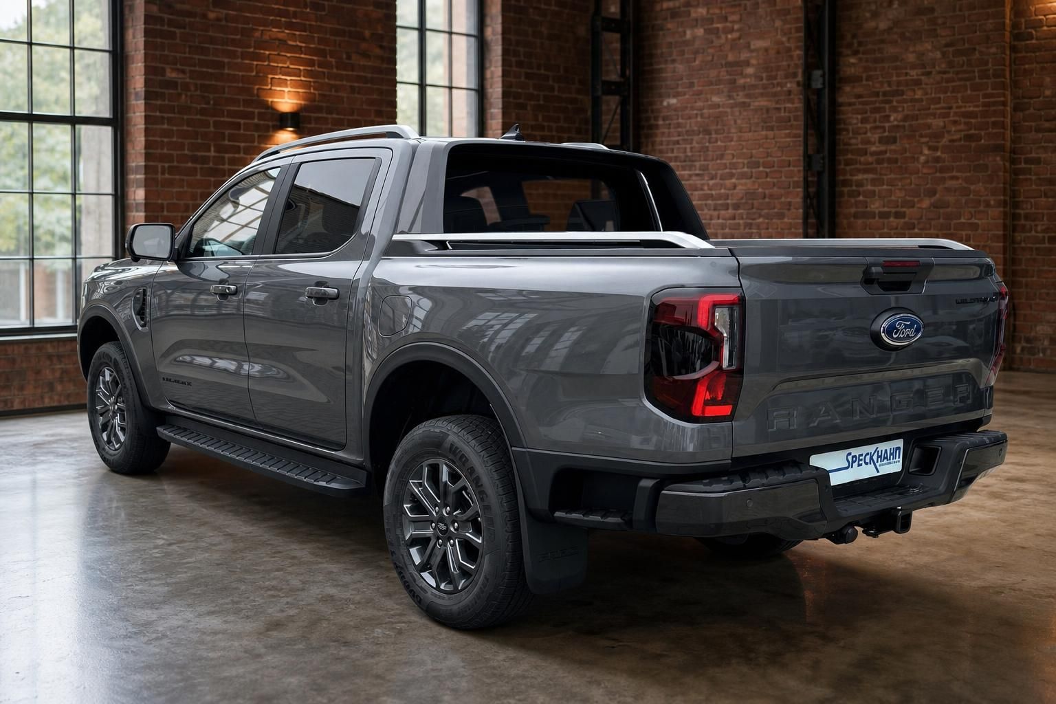 Ford Ranger Wildtrak grau, Heckansicht schraeg im Showroom