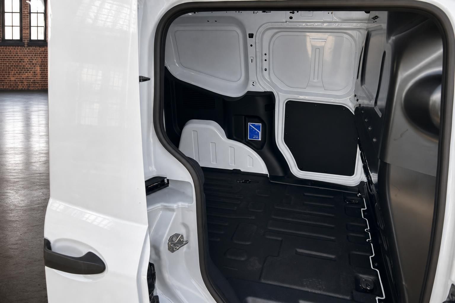 Leerer Laderaum eines weißen Ford Transit Nutzfahrzeugs mit offener Schiebetür