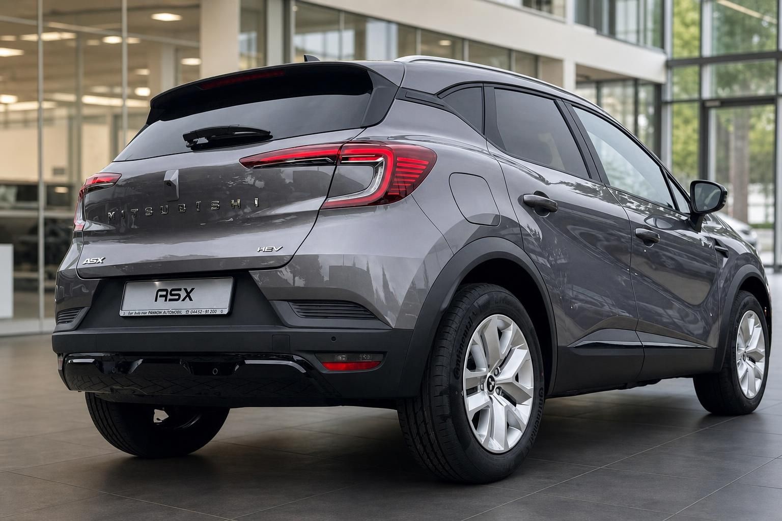 Mitsubishi ASX HEV grau, Heckansicht seitlich im Autohaus