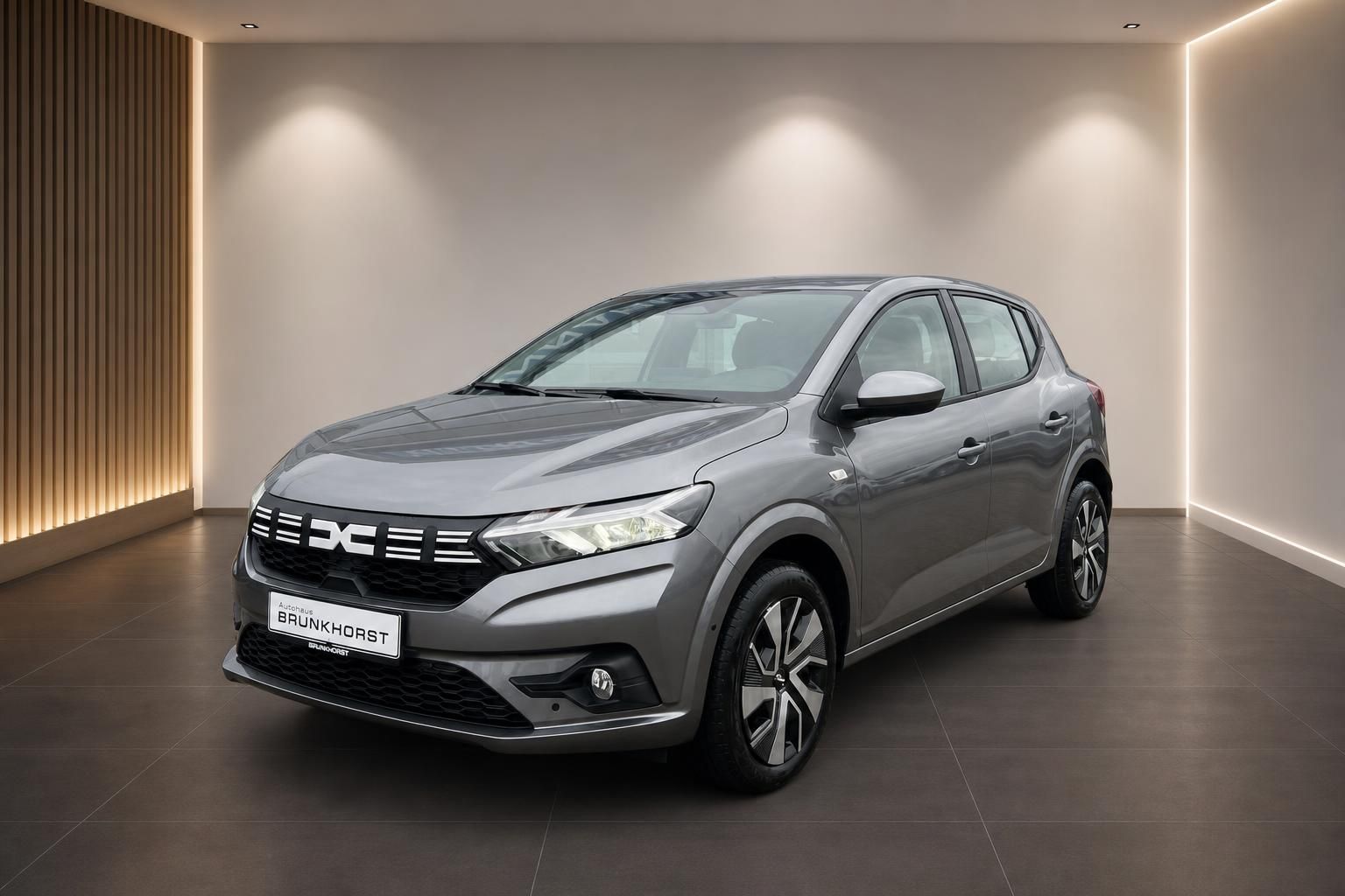 Dacia grau Seitenansicht mit DC-Design im edlen Autohaus Brunkhorst Ausstellungsraum