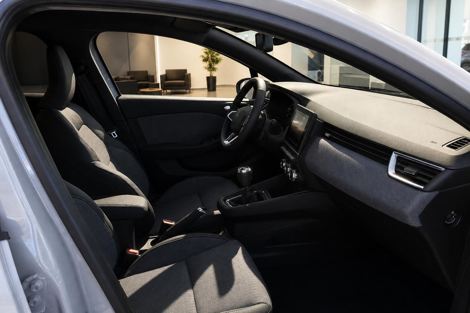 Innenraum eines Fahrzeugs mit Lenkrad, Armaturenbrett und Touchscreen-Display