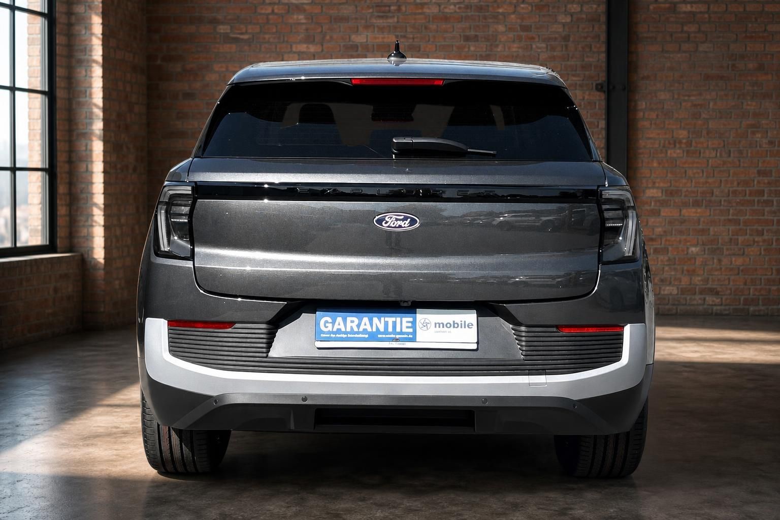 Ford Explorer Elektro grau Heckansicht gerade im Showroom – Elektro-SUV Angebot