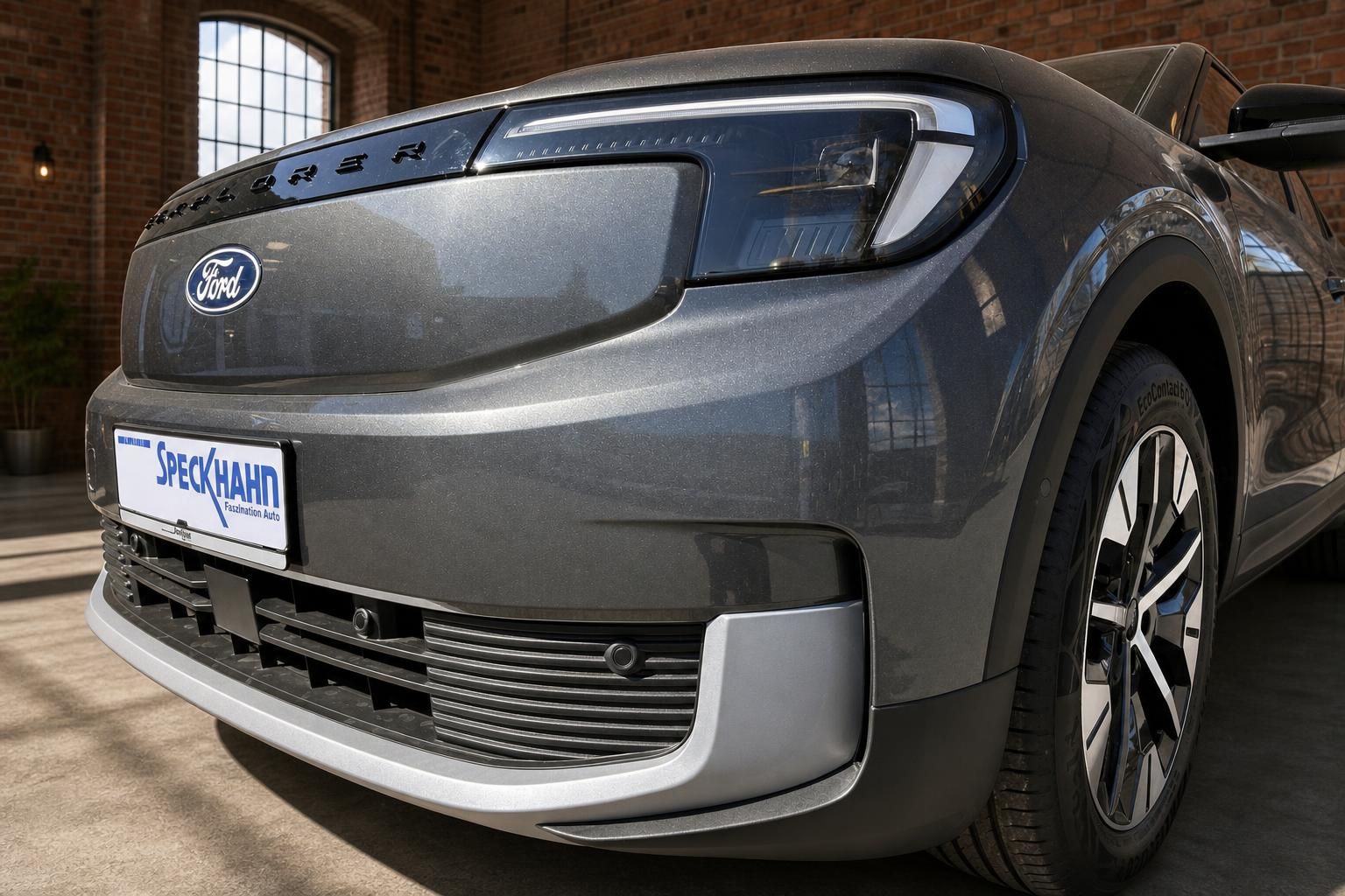 Ford Explorer Elektro SUV grau Detailansicht Front mit LED-Scheinwerfer und Speckhahn Kennzeichenhalter