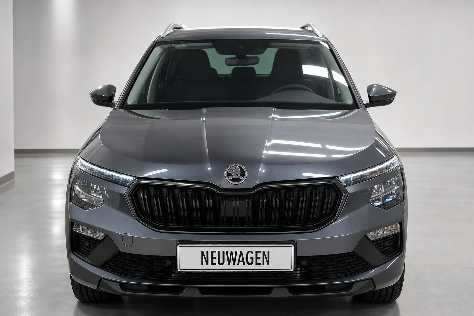 Skoda Kamiq in Grau, Frontansicht mit markantem Kuehlergrill im Studio