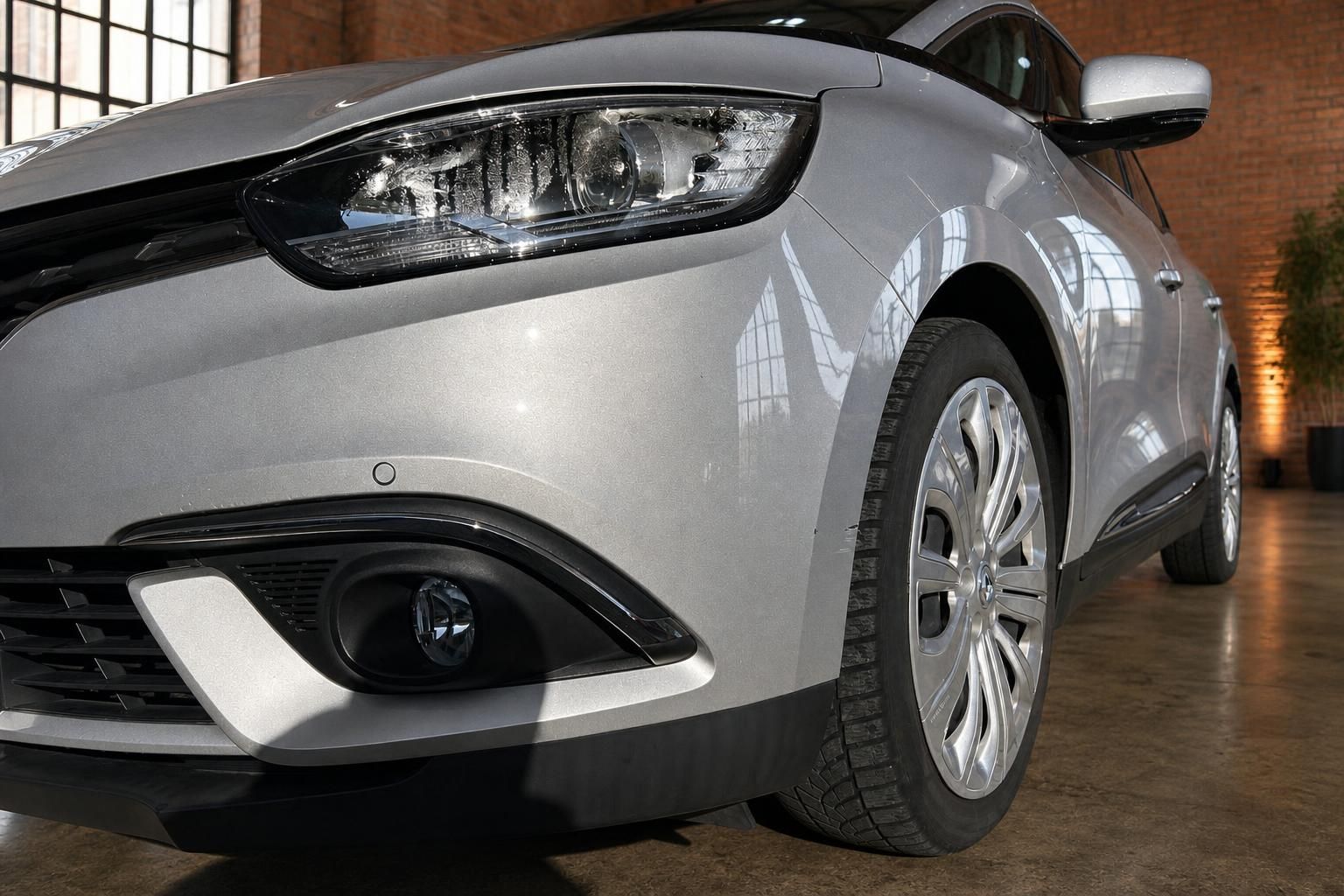 Renault Scenic silber Detailaufnahme Frontscheinwerfer und Alufelge seitlich schräg