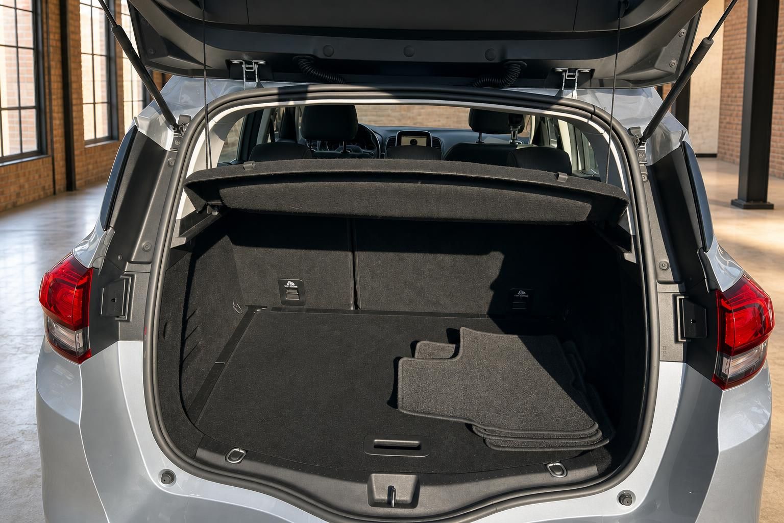 Renault Scenic Kofferraum geöffnet mit Laderaumabdeckung und Fußmatten von hinten