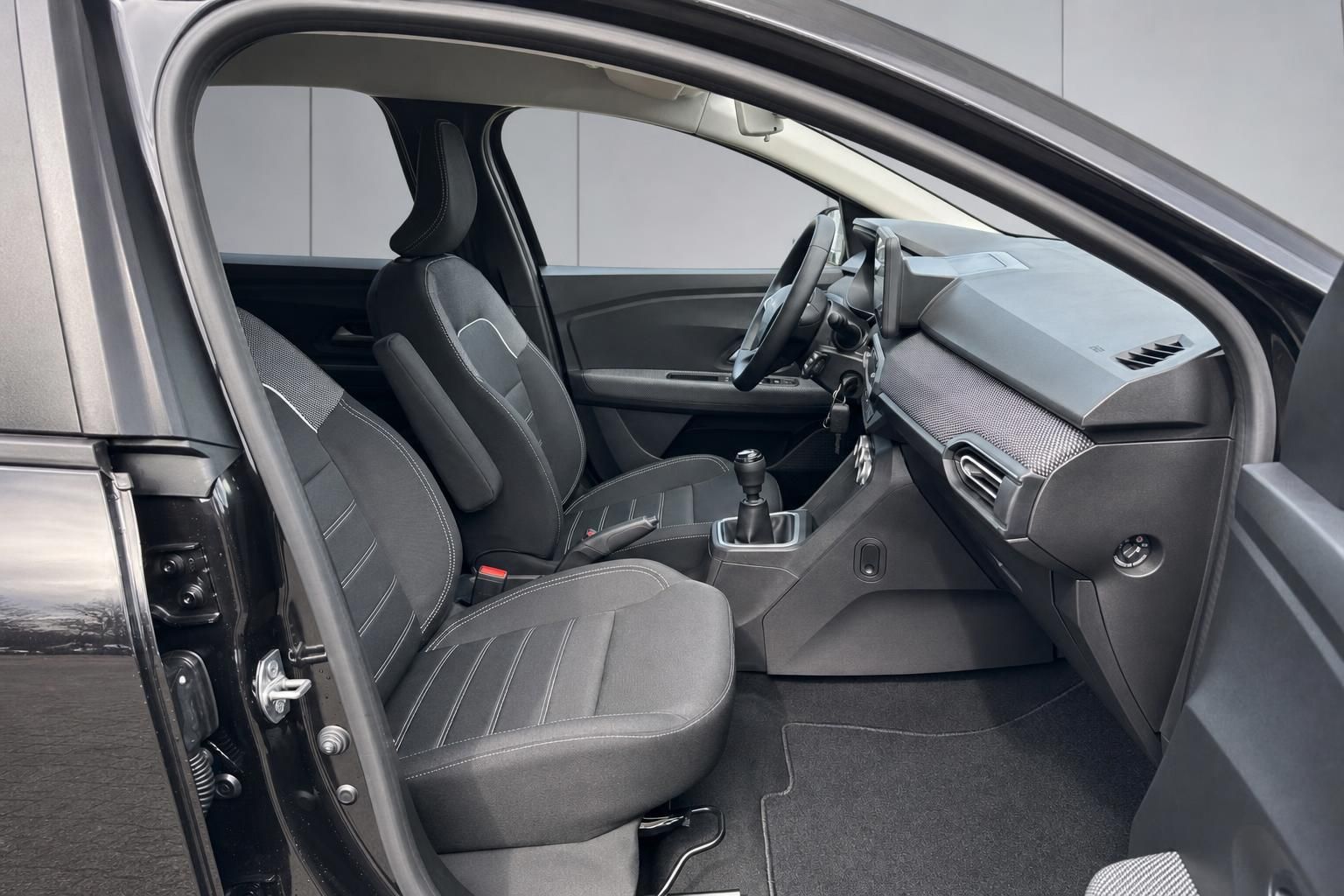 Dacia Innenraum Beifahrerseite mit Sitzen, Schaltung und Dashboard-Übersicht