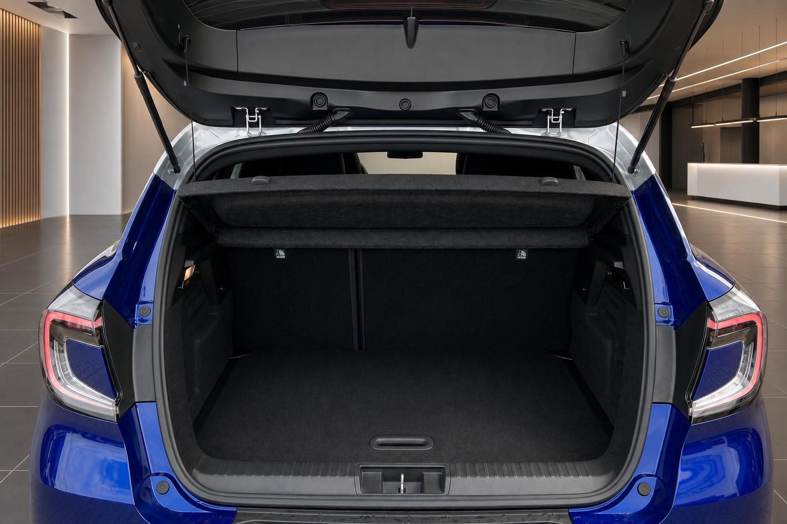 Offener Kofferraum eines blauen Elektroautos mit schwarzer Innenausstattung und geöffneter Heckklappe