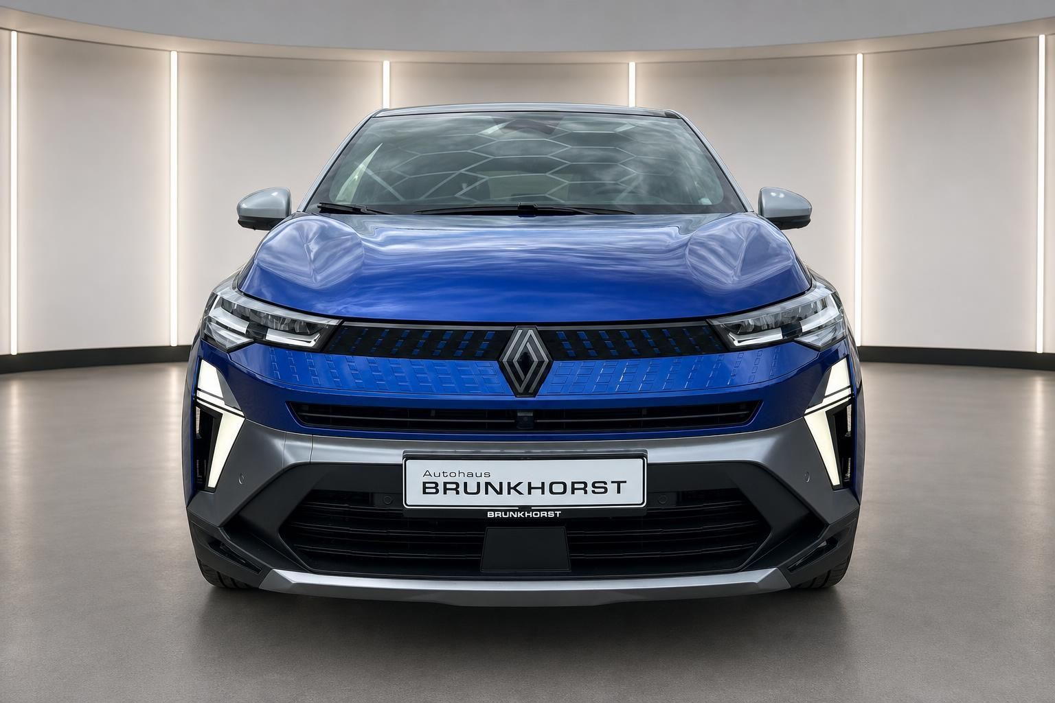 Blauer Renault Captur Frontansicht mit charakteristischem Kühlergrill und LED-Scheinwerfern im Showroom
