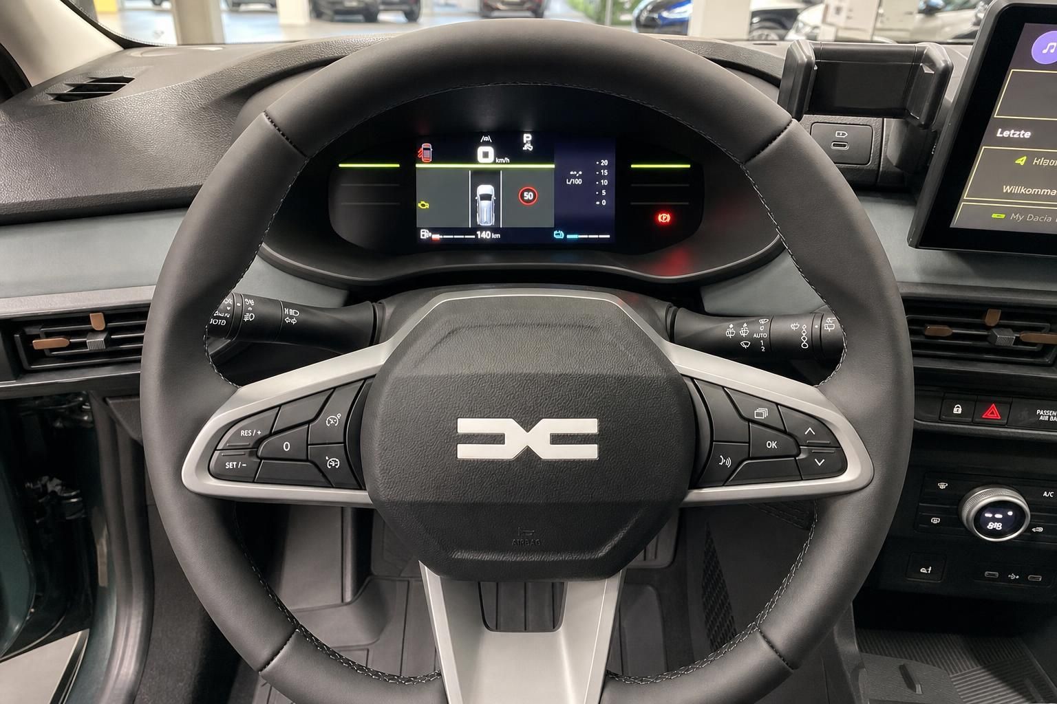 Multifunktionslenkrad mit DC-Logo und digitalem Display hinter dem Lenkrad im modernen Cockpit