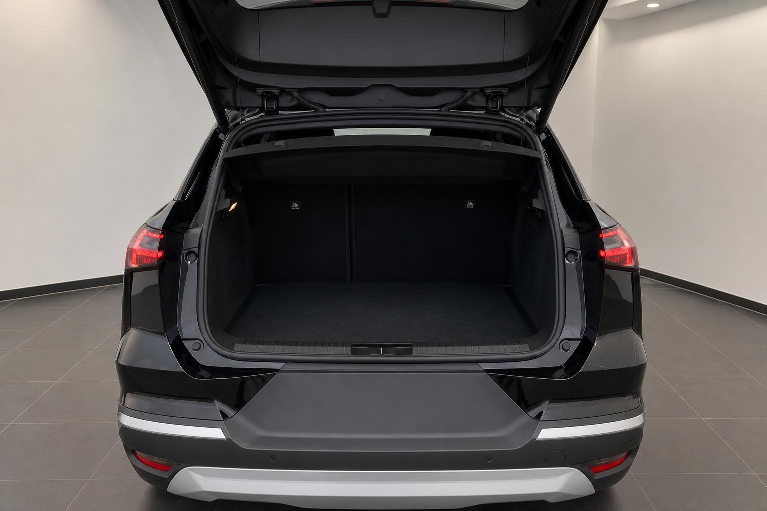 Kofferraum eines schwarzen SUV mit geoeffneter Heckklappe und viel Stauraum