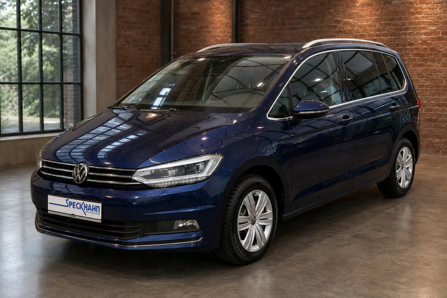 VW Touran blau metallic Frontansicht schräg im Showroom