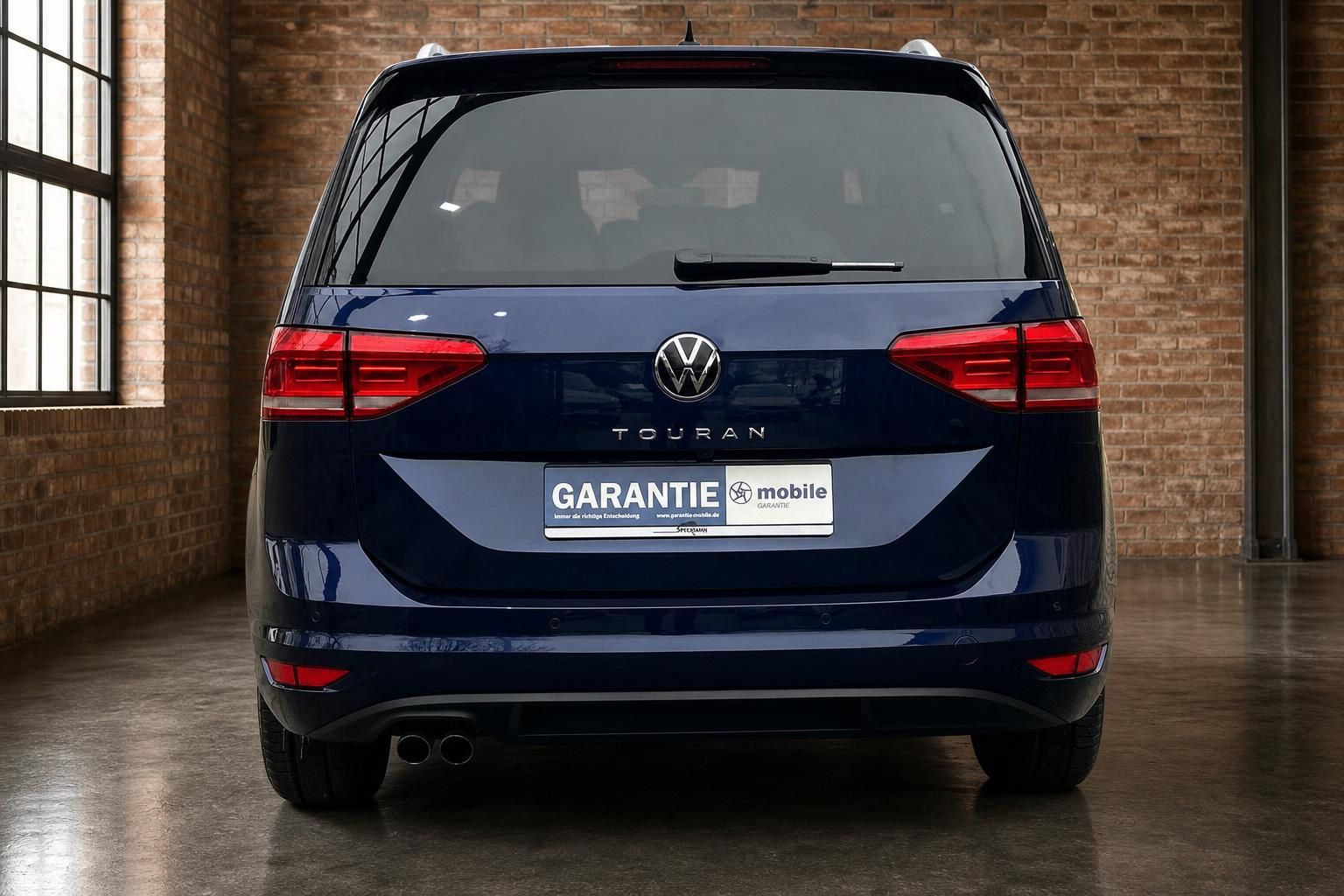 VW Touran blau metallic Heckansicht frontal im Loft
