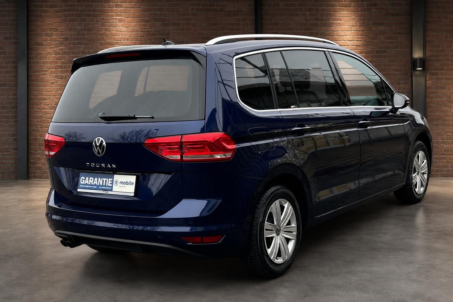 VW Touran dunkelblau Heckansicht schräg mit Alufelgen