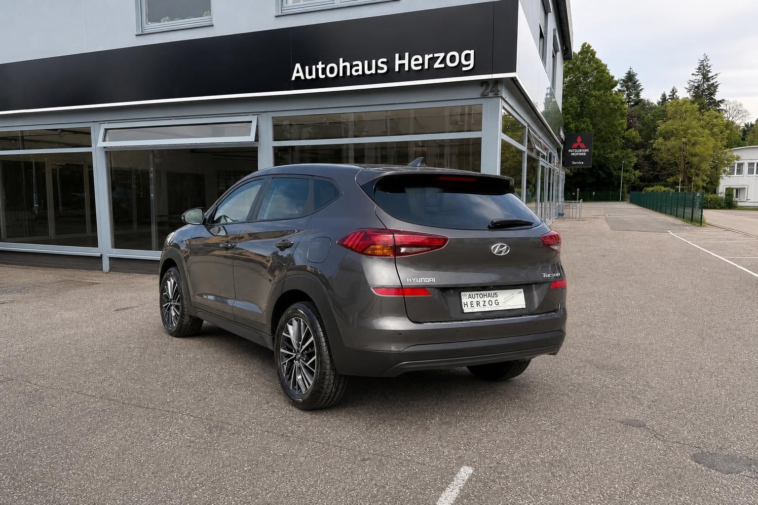 Hyundai Tucson Heckansicht schräg vor Autohaus Herzog