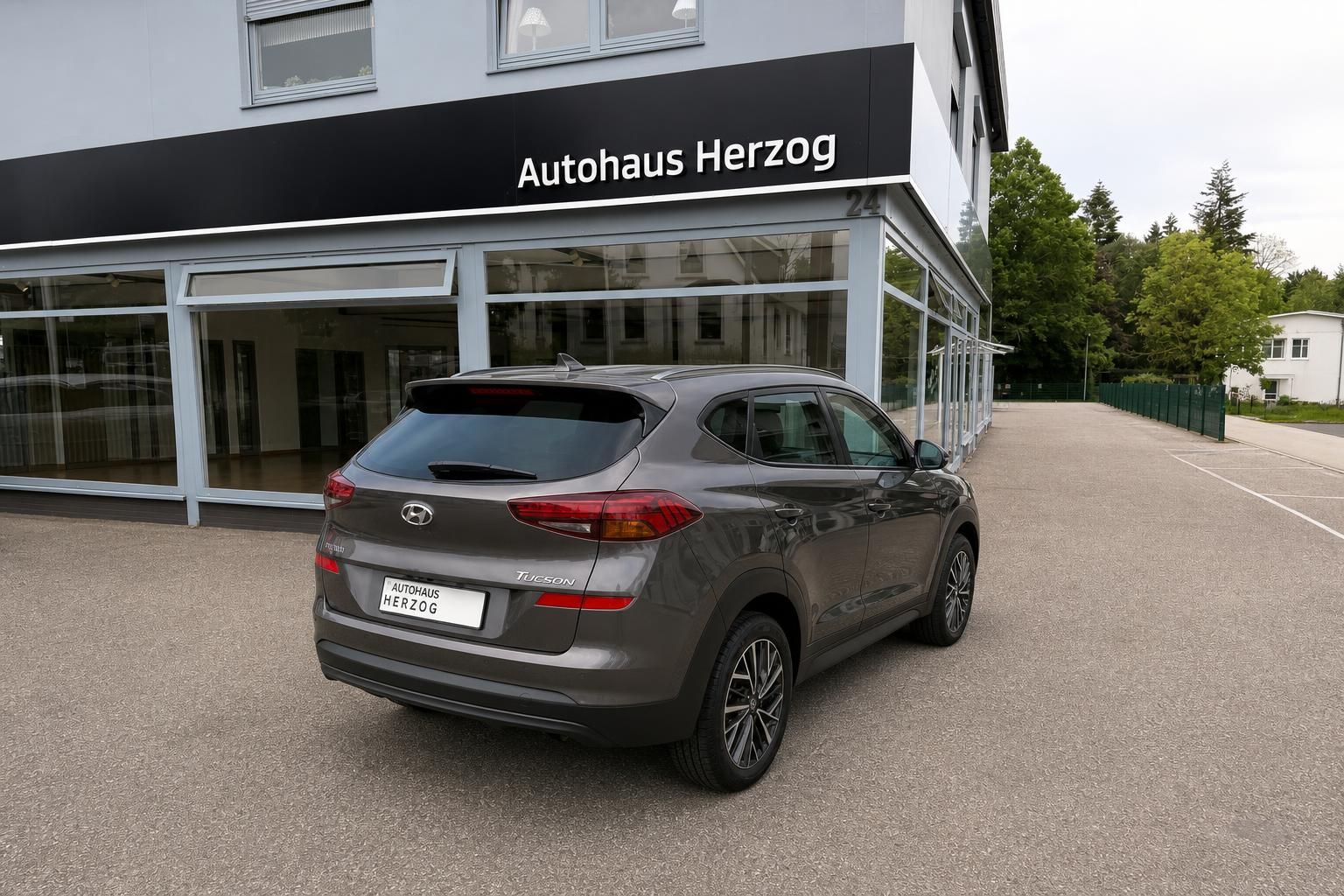 Hyundai Tucson Heck schräg links vor Autohaus Herzog