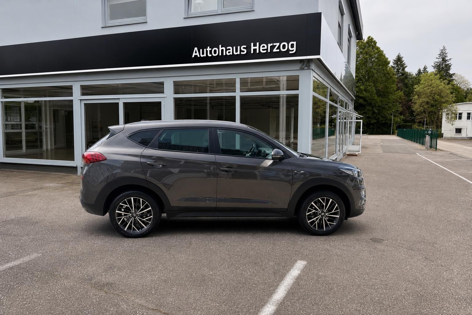 Hyundai Tucson grau Seitenansicht vor Autohaus Herzog