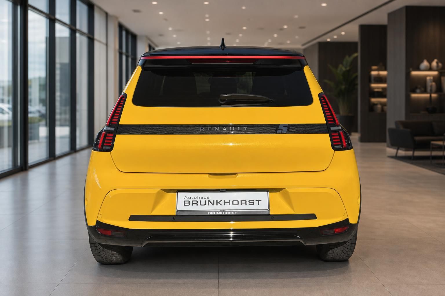 Renault 5 gelb, Heckansicht mit LED-Rückleuchten im Showroom