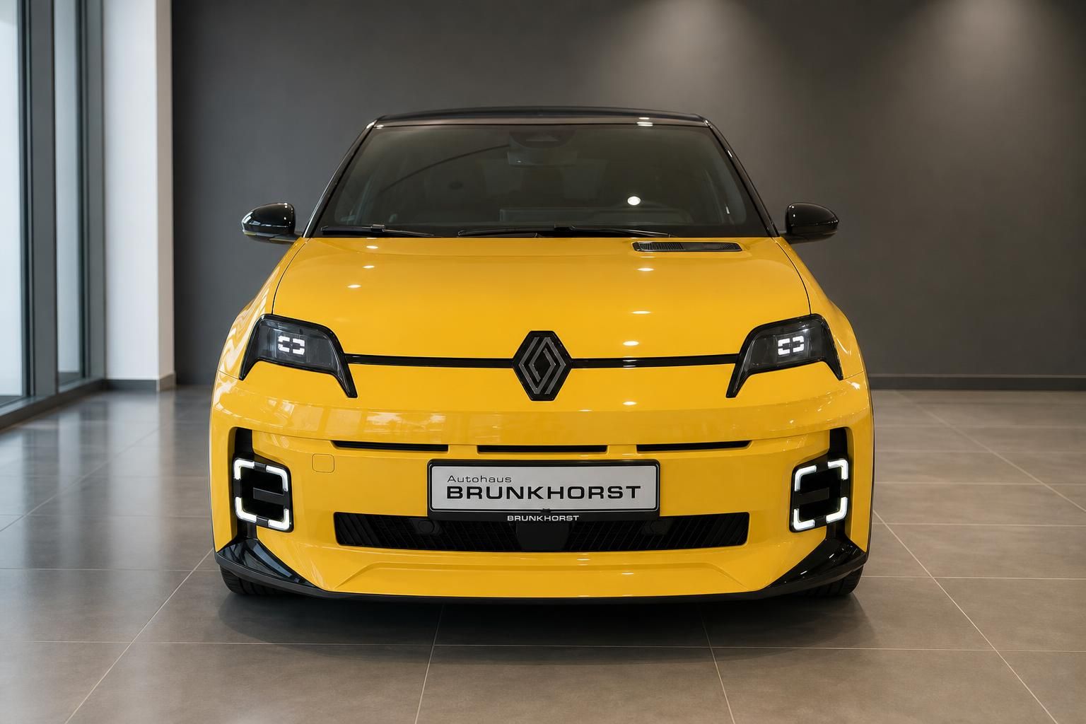 Renault 5 in Gelb, Frontansicht mit LED-Scheinwerfern im Autohaus