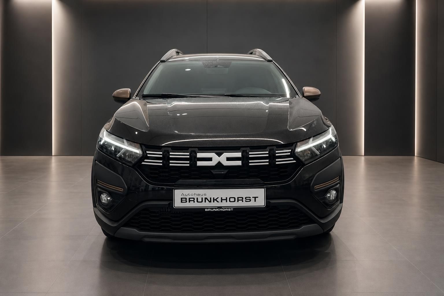 Dacia SUV schwarz Frontansicht mit Autohaus Brunkhorst Kennzeichen im Showroom
