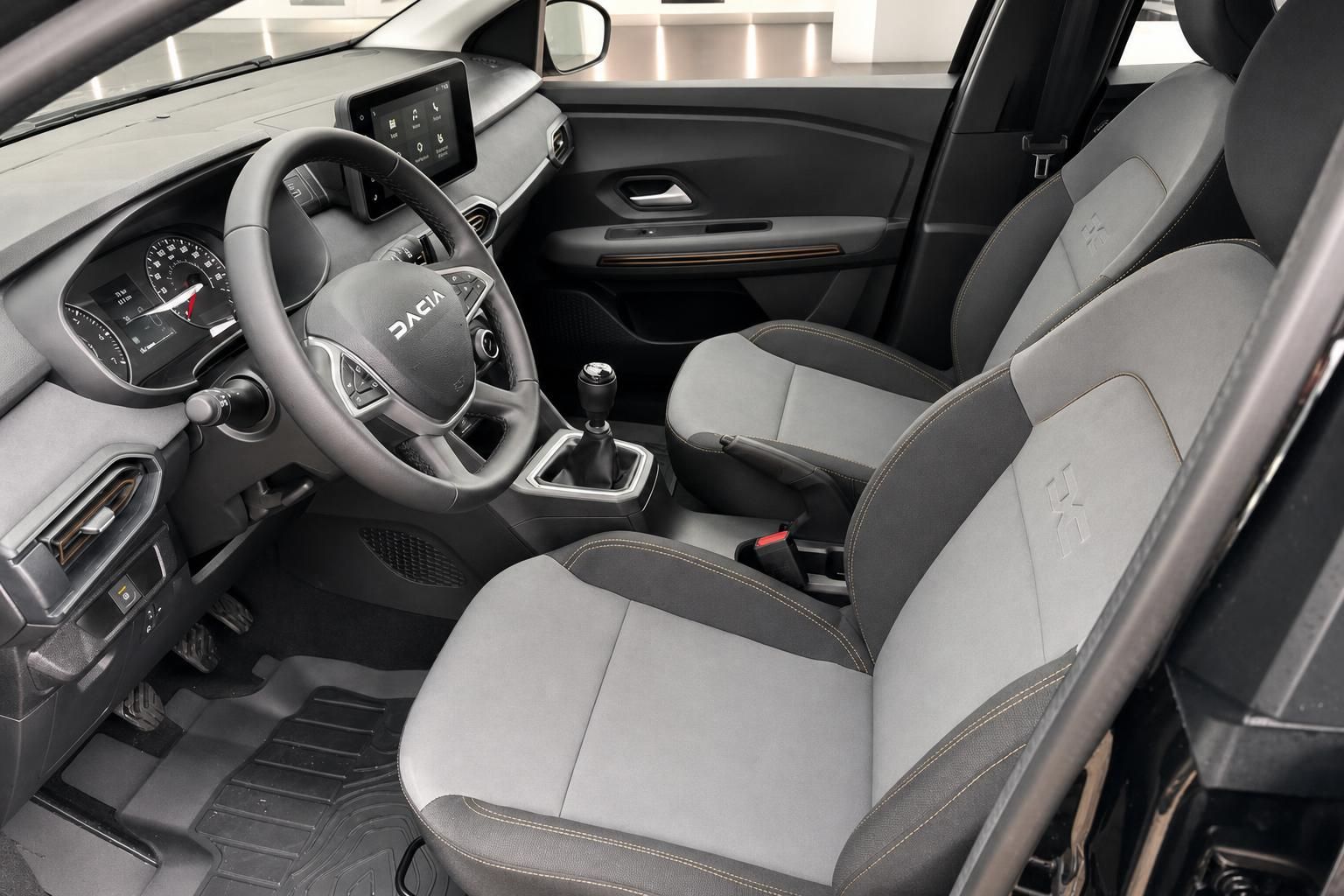 Dacia Innenraum Frontansicht mit Lenkrad, Cockpit und grau-schwarzer Sitzausstattung