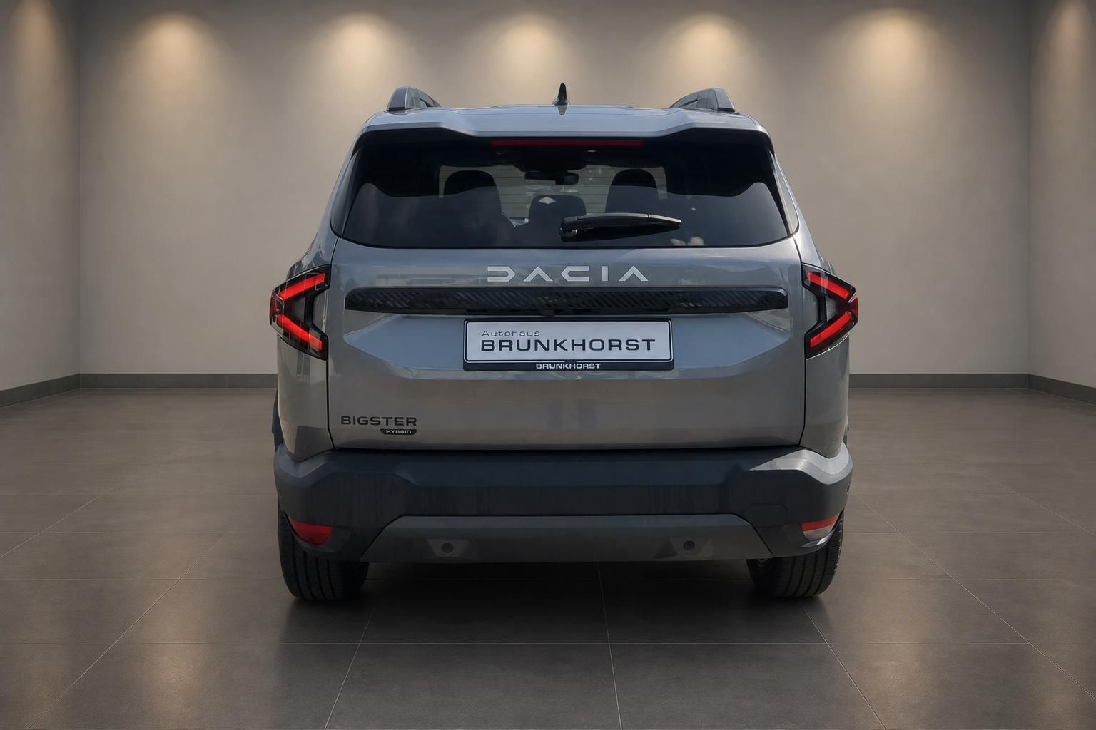 Dacia Bigster Hybrid grau Heckansicht mit LED-Rückleuchten im Showroom