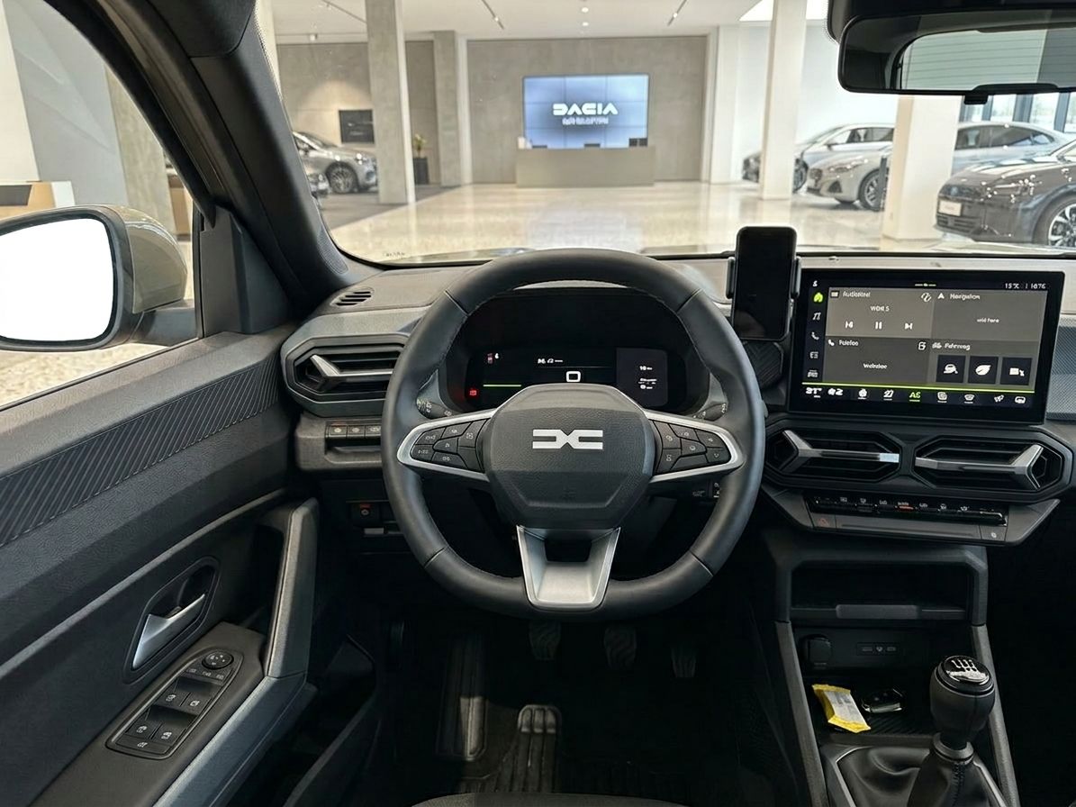 Innenraum eines Fahrzeugs mit Lenkrad, Touchscreen und Schaltknauf in Autohaus-Umgebung