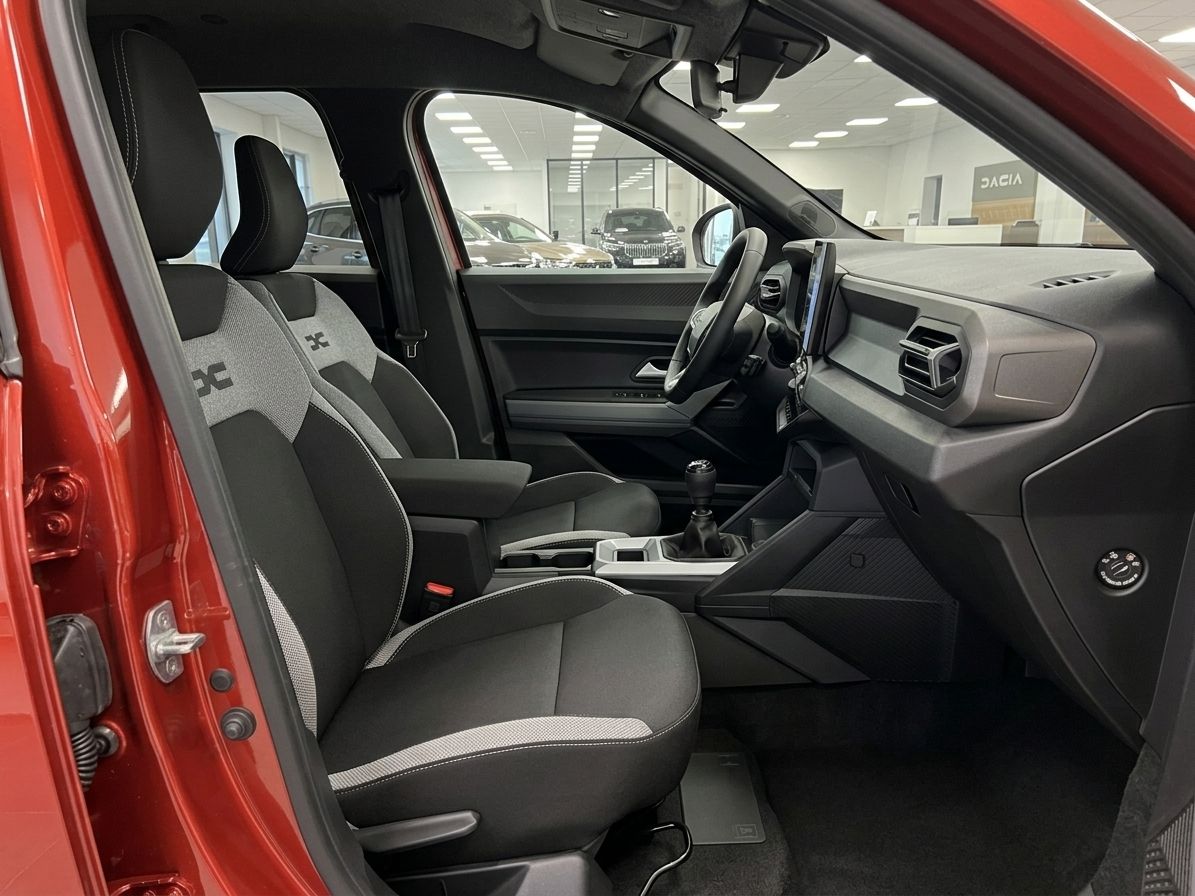 Fahrzeuginnenraum mit Sportsitzen und modernem Cockpit-Design in rotem Auto