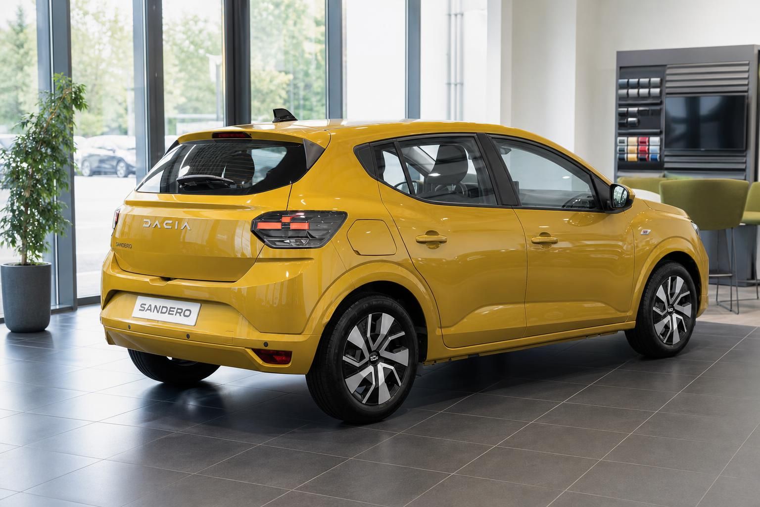 Dacia Sandero gelb - Heck- und Seitenansicht des modernen Kompaktwagens im Ausstellungsraum