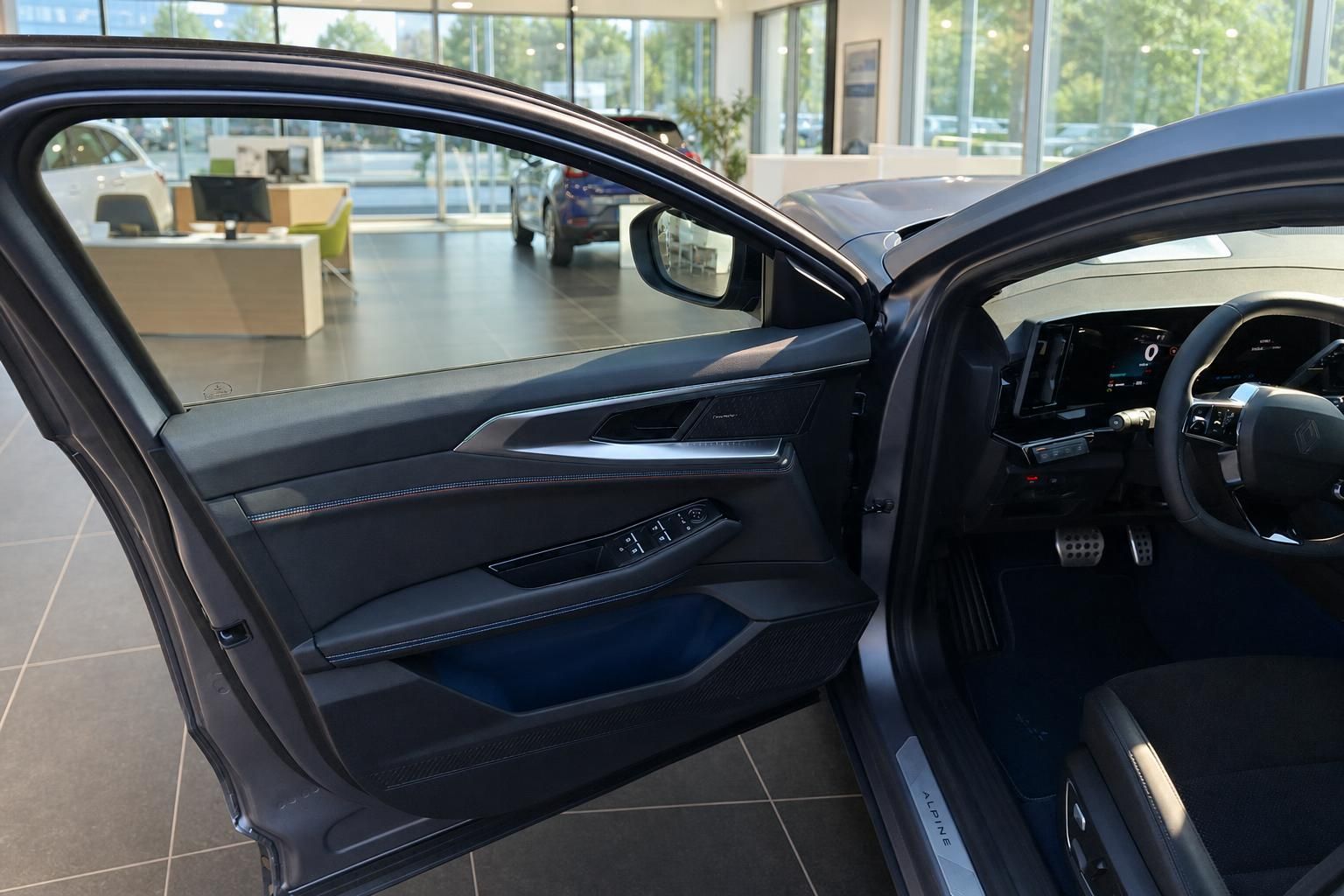 Alpine Fahrzeug Innenraum mit geoeffneter Fahrertuer im Autohaus