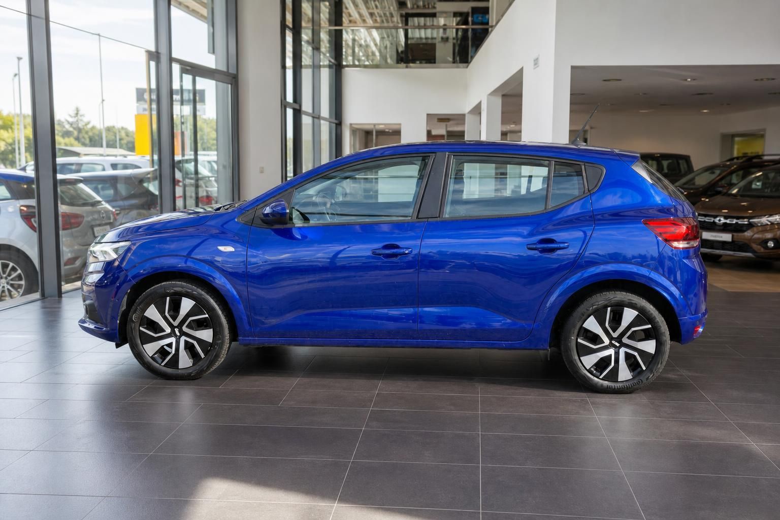 Blauer Dacia Sandero Seitenansicht im Autohaus Showroom