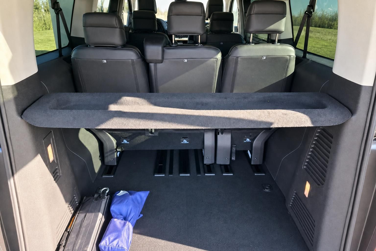 Van Innenraum Kofferraum mit umgeklappter Sitzbank und blauem Gegenstand im Freien