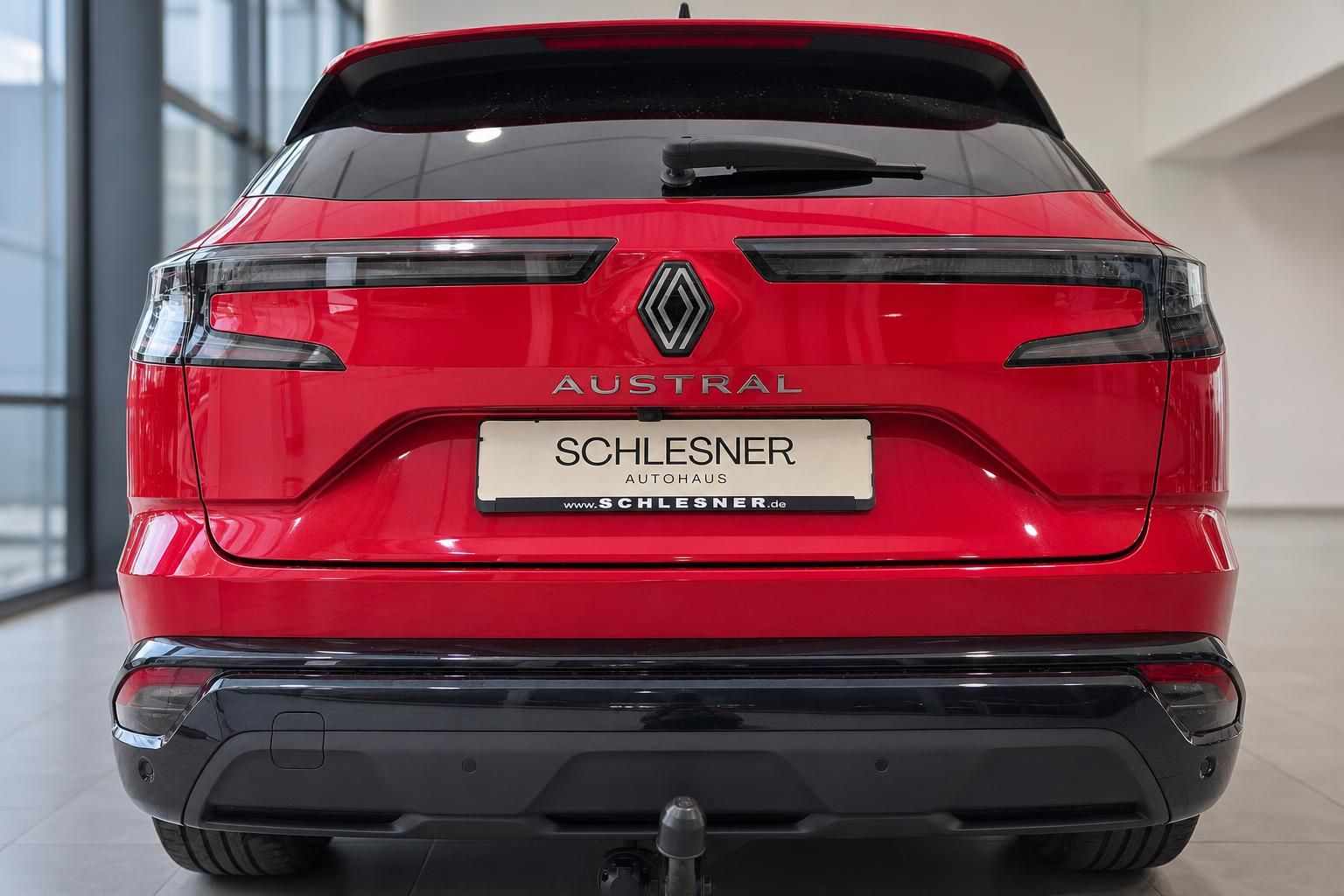Renault Austral in Rot, Heckansicht mit Anhaengerkupplung im Autohaus