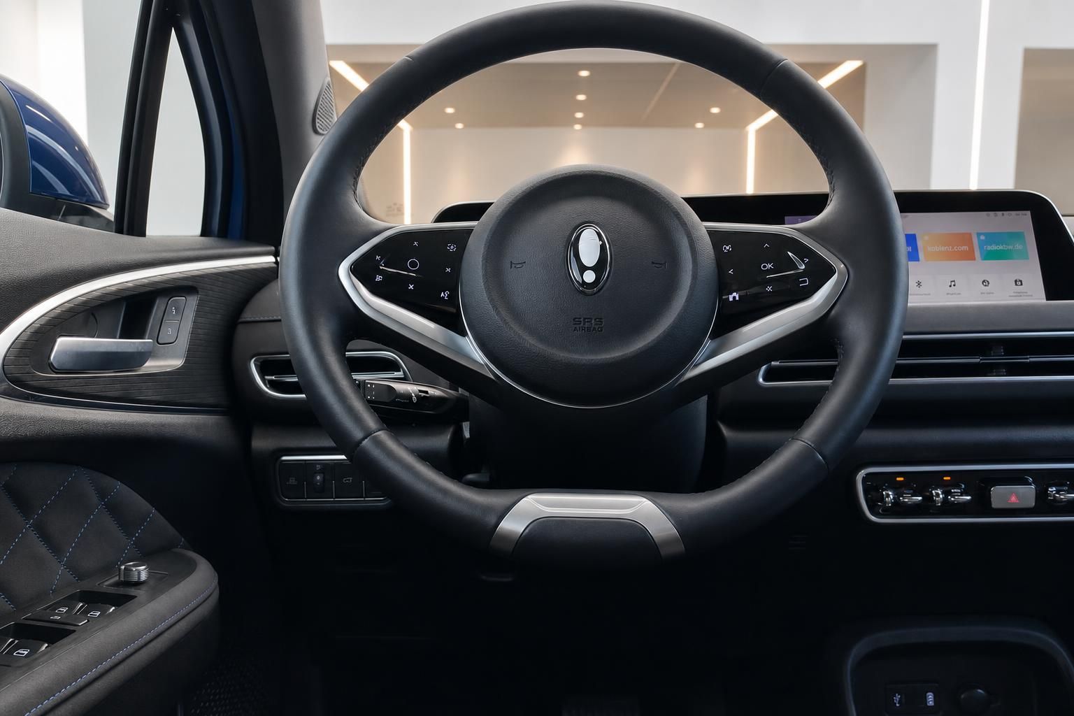 Eleganter Innenraum mit schwarzem Lenkrad und modernem Infotainment-System - Fahrzeug-Cockpit