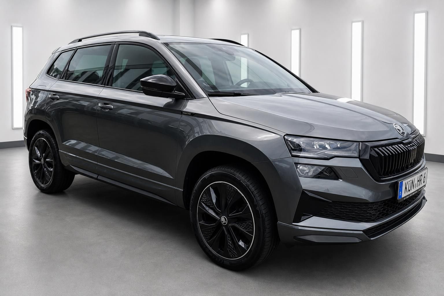 Skoda Karoq SUV grau, Frontansicht schraeg in Ausstellung
