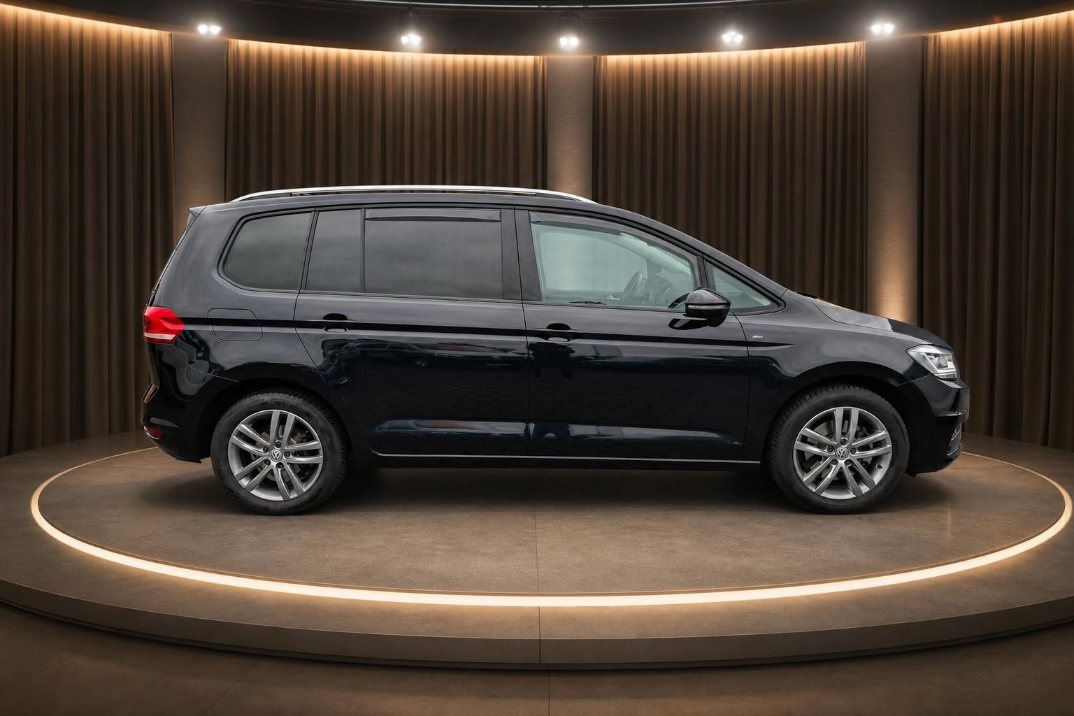 Schwarzer Volkswagen Touran Seitenansicht mit Alufelgen und getönten Scheiben