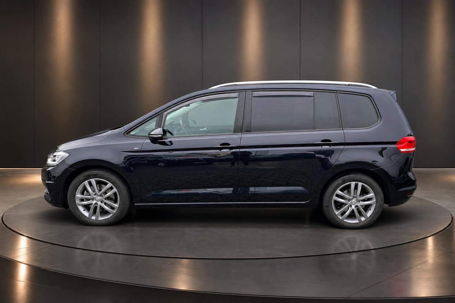 Volkswagen Touran Seitenansicht dunkelblau - Van mit Alufelgen im Showroom